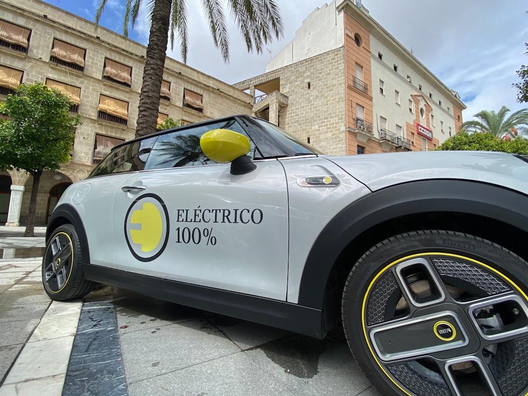 Carro prateado estacionado próximo a edifício durante o dia